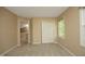 Neutral carpeted bedroom featuring a closet, large window, and access to additional spaces at 105 Old Dock Trl, Cary, NC 27519