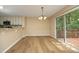 Cozy dining area with hardwood floors, a modern chandelier, and sliding glass doors leading to a deck at 105 Old Dock Trl, Cary, NC 27519