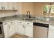 Close-up of a kitchen area with stainless steel appliances, granite countertops, and white cabinetry at 105 Old Dock Trl, Cary, NC 27519