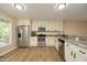 Well-lit kitchen boasting stainless steel appliances, granite countertops, and ample cabinetry space at 105 Old Dock Trl, Cary, NC 27519