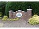 Brick community entrance sign with manicured landscaping in a residential neighborhood at 105 Old Dock Trl, Cary, NC 27519
