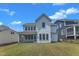 Beautiful backyard view of the home, featuring a screened-in porch and large windows at 109 Crested Coral Dr, Holly Springs, NC 27540