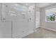 Bright bathroom featuring a walk-in shower with white subway tile and glass door, complemented by light wood-look flooring at 109 Crested Coral Dr, Holly Springs, NC 27540