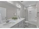 Bright bathroom with double sinks, light gray cabinets, and a shower-tub combo with a patterned curtain at 109 Crested Coral Dr, Holly Springs, NC 27540