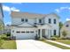 Beautiful two-story white home boasts a two-car garage, manicured lawn, and a bright exterior at 109 Crested Coral Dr, Holly Springs, NC 27540