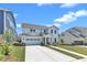 Charming two-story white home featuring a two-car garage and landscaped front yard at 109 Crested Coral Dr, Holly Springs, NC 27540