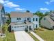 Charming two-story white home featuring a two-car garage and landscaped front yard at 109 Crested Coral Dr, Holly Springs, NC 27540