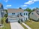 Charming two-story white home featuring a two-car garage and landscaped front yard at 109 Crested Coral Dr, Holly Springs, NC 27540