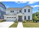 Charming two-story white home featuring a two-car garage, well-manicured lawn, and sidewalk leading to the front porch at 109 Crested Coral Dr, Holly Springs, NC 27540