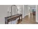 Stylish foyer with hardwood floors, a decorative console table with mirror, and an inviting entrance to the home at 109 Crested Coral Dr, Holly Springs, NC 27540