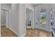 Bright foyer with hardwood floors, a glass-paneled front door, and views into the adjacent rooms at 109 Crested Coral Dr, Holly Springs, NC 27540