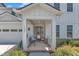 Inviting front porch with seating, decorative plants, and a stylish front door, perfect for relaxing outdoors at 109 Crested Coral Dr, Holly Springs, NC 27540