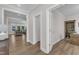 Hallway with hardwood floors leads to the living room and features a built-in bookcase at 109 Crested Coral Dr, Holly Springs, NC 27540