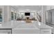 Open concept kitchen with bright white countertops and stainless steel appliances opens to living room with fireplace at 109 Crested Coral Dr, Holly Springs, NC 27540