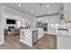 Open concept kitchen with stainless steel appliances and a view into the living room at 109 Crested Coral Dr, Holly Springs, NC 27540
