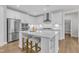 Bright eat-in kitchen featuring an island with stool seating, stainless appliances, and white cabinetry at 109 Crested Coral Dr, Holly Springs, NC 27540