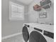 Laundry room featuring modern washer and dryer with overhead shelving and a view to the outside at 109 Crested Coral Dr, Holly Springs, NC 27540