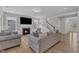 Living room with a fireplace, mounted tv, neutral paint and staircase to the second floor at 109 Crested Coral Dr, Holly Springs, NC 27540