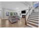 Bright and airy living room features a fireplace, large windows, hardwood floors, and a comfortable seating area at 109 Crested Coral Dr, Holly Springs, NC 27540