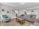 Open concept living room with kitchen and staircase with hardwood flooring and a view to the back yard at 109 Crested Coral Dr, Holly Springs, NC 27540