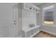 Inviting mudroom with a bench, storage cubbies, hooks, and a window for natural light, ideal for organization at 109 Crested Coral Dr, Holly Springs, NC 27540