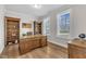 Elegant home office featuring a large wooden desk, built-in bookshelves, and ample natural light from shuttered windows at 109 Crested Coral Dr, Holly Springs, NC 27540