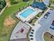 A high angle showcases a community pool with a playground and parking spots close by at 109 Crested Coral Dr, Holly Springs, NC 27540