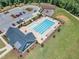 Aerial view of a community pool, playground, and parking, surrounded by lush greenery at 109 Crested Coral Dr, Holly Springs, NC 27540