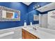 Nicely decorated bathroom with a white vanity, nautical themed mirror, and blue painted walls at 111 Ferncroft Ct, Cary, NC 27519