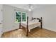 Traditional bedroom featuring a four-poster bed with a light-colored comforter, hardwood floors, and a window at 111 Ferncroft Ct, Cary, NC 27519