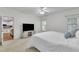 Bright bedroom with a neutral color palette, a ceiling fan, and a TV on a distressed cabinet at 111 Ferncroft Ct, Cary, NC 27519