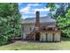 Exterior of home with deck, chimney, and stairs, surrounded by lush backyard at 111 Ferncroft Ct, Cary, NC 27519