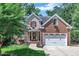 Charming home featuring a two-car garage, beautiful lawn and manicured shrubbery and trees at 111 Ferncroft Ct, Cary, NC 27519