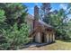 Exterior view of house with deck and brick chimney, backing to mature trees at 111 Ferncroft Ct, Cary, NC 27519