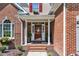 Charming entryway with red brick, white columns, and a decorative front door at 111 Ferncroft Ct, Cary, NC 27519
