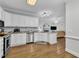 Modern white kitchen flows into living room with hardwood flooring and granite counters at 111 Ferncroft Ct, Cary, NC 27519