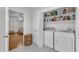 Laundry area with a washer, dryer, shelving, and a storage basket at 111 Ferncroft Ct, Cary, NC 27519