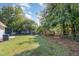 A spacious backyard featuring a large lawn, mature trees, and a chain-link fence at 1110 Allgood St, Durham, NC 27704