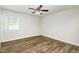 An empty bedroom showcasing a ceiling fan, window with blinds, and wood-look flooring at 1110 Allgood St, Durham, NC 27704