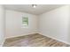 Bright bedroom with a window, flush mount light, and neutral walls and wood-look floors at 1110 Allgood St, Durham, NC 27704
