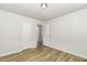 A bedroom featuring white walls, recessed lighting, wood-look flooring, and access to the hallway at 1110 Allgood St, Durham, NC 27704
