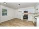 Updated kitchen with stainless steel appliances, white cabinetry, and wood-look flooring at 1110 Allgood St, Durham, NC 27704
