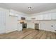 Modern kitchen featuring stainless steel appliances, white cabinets, and wood-look flooring at 1110 Allgood St, Durham, NC 27704