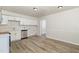 Bright kitchen with white cabinets, stainless steel appliances, and wood-look floors at 1110 Allgood St, Durham, NC 27704