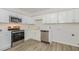 Well-lit kitchen featuring white cabinets, stainless steel appliances and wood-look flooring at 1110 Allgood St, Durham, NC 27704