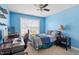 Stylized blue bedroom featuring a dark wood desk, shelves, and window for natural light at 1161 Tulip Poplar Rd, Fuquay Varina, NC 27526