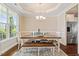 Dining room featuring tray ceilings, a chandelier, and a view into the kitchen with stainless steel appliances at 1161 Tulip Poplar Rd, Fuquay Varina, NC 27526