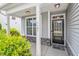 Inviting front porch with a black front door, stone accents, white columns, and manicured landscaping at 1161 Tulip Poplar Rd, Fuquay Varina, NC 27526