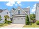 Charming two-story home with a two car garage, stone accents, manicured lawn, and mature landscaping at 1161 Tulip Poplar Rd, Fuquay Varina, NC 27526