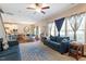 Bright living room featuring an open floor plan, large windows with curtains, and seamless flow to the kitchen at 1161 Tulip Poplar Rd, Fuquay Varina, NC 27526